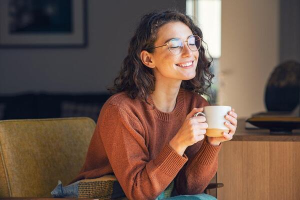 Person taking a short break with a warm drink at a tidy desk
